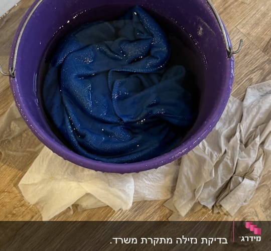 דלי סגול עם מים ובד כחול רטוב